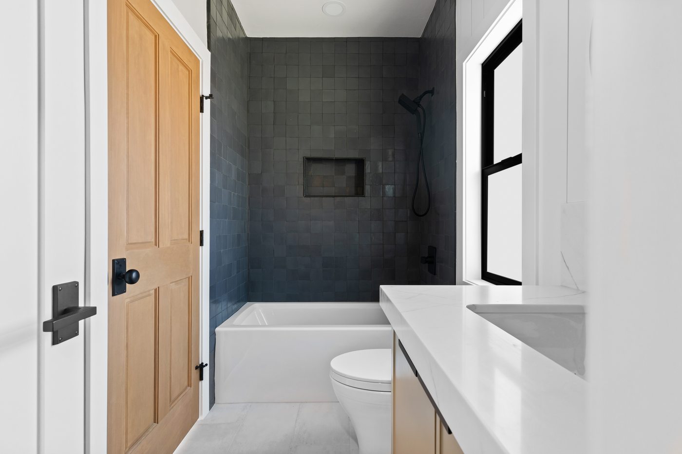 Dark tiled bathroom with wood door, Scottsdale whole-home remodel