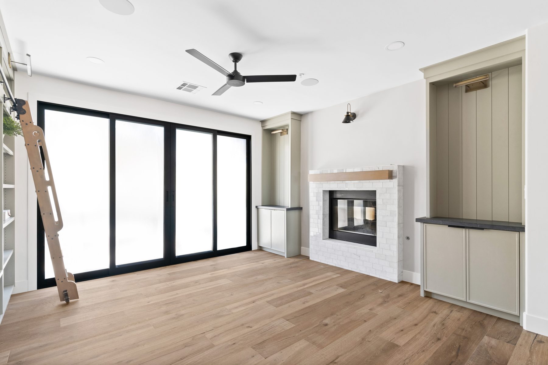 Living room with fireplace and floor-to-ceiling sliding glass doors opening to the backyard, whole-home remodel, Scottsdale