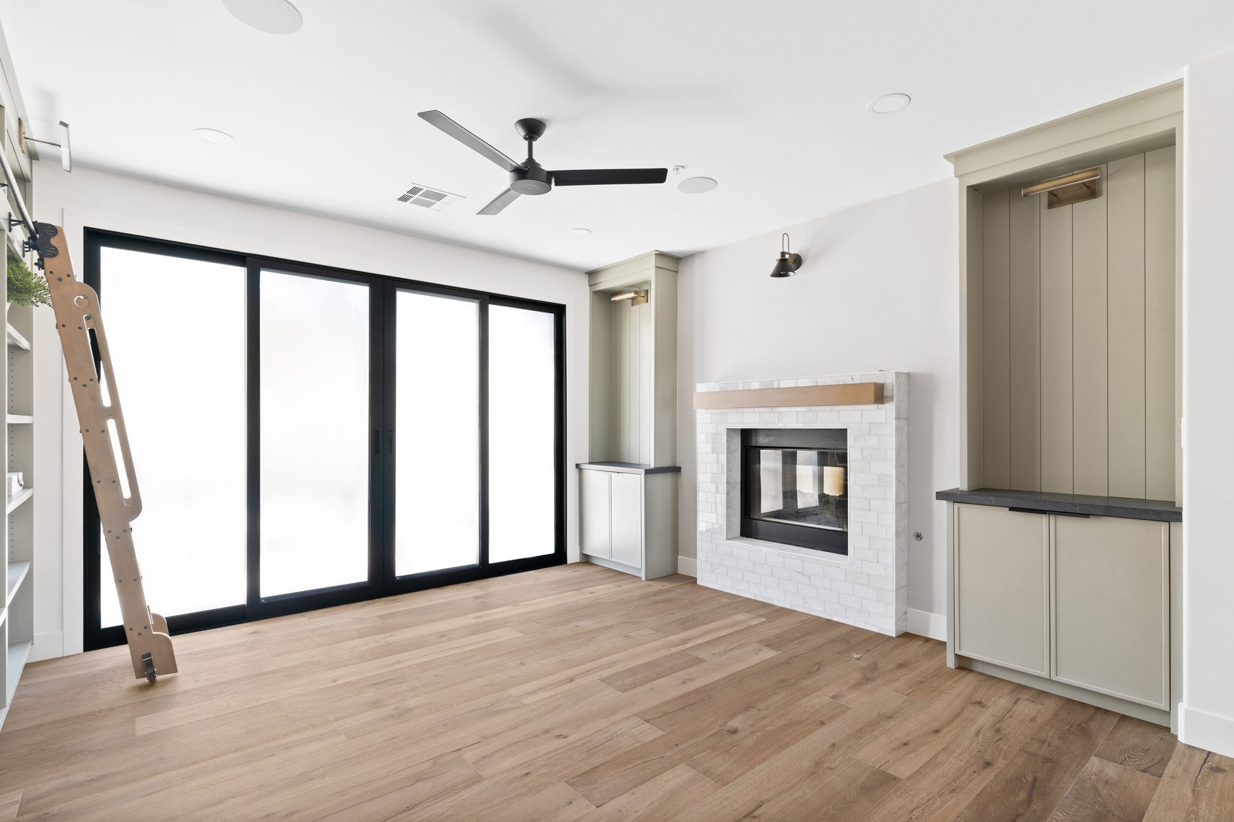 Living room with fireplace and floor-to-ceiling sliding glass doors opening to the backyard, Manning residence remodel, Scottsdale