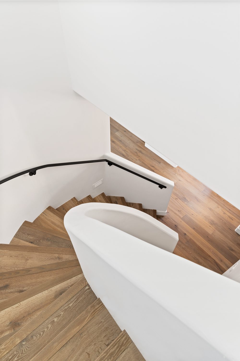 Curved staircase with white plaster wall and wood treads, Manning residence, Scottsdale