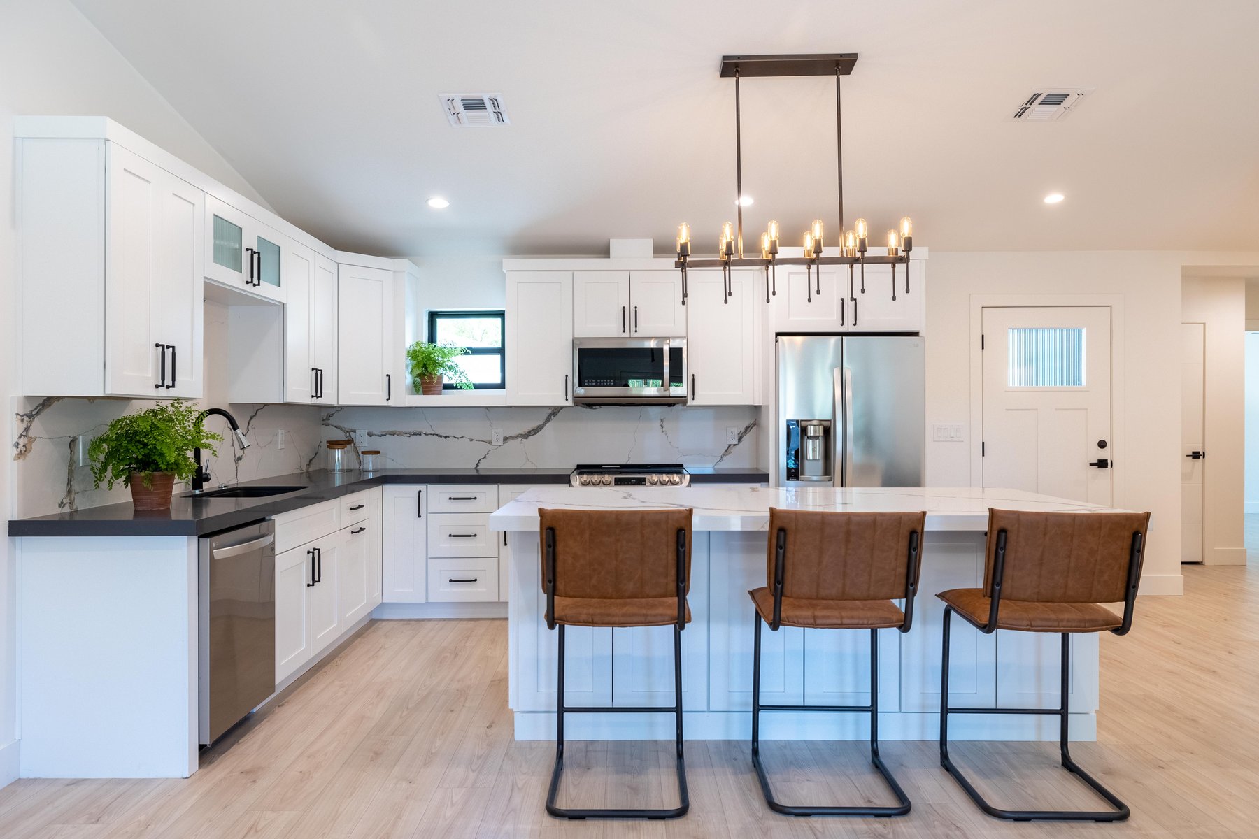 ADU kitchen with white cabinetry and marble backsplash, Trinity Homes Remodeling project