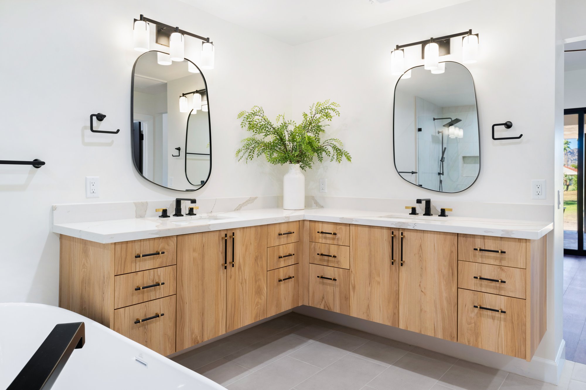 Primary bathroom with L-shaped double vanity and wood cabinetry, Trinity Homes Remodeling project